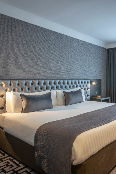 hotel room with large king bed, stylish decor and night stand